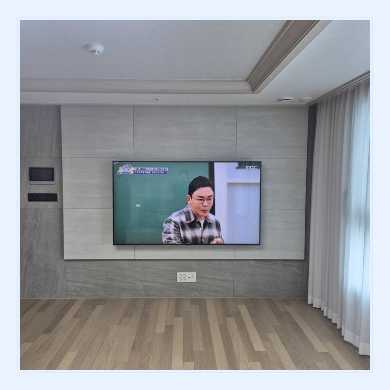 벽면에 걸린 TV와 창가 쪽 간격와 기기 환기와 수납 공간 안내 사진