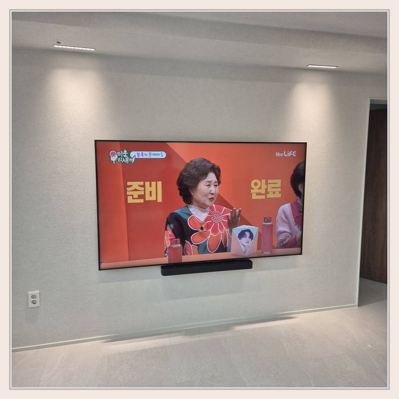 밝은 실내 벽걸이 화면의 중심선와 석재 벽면 체결 방법 확인 안내 사진