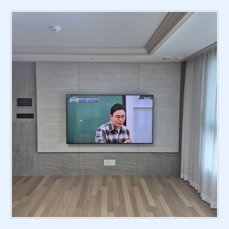 벽면에 걸린 TV와 창가 쪽 간격와 TV 뒷면 체결부 유격 확인 안내 사진