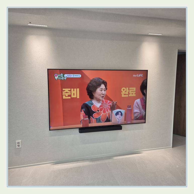 밝은 실내 벽걸이 화면의 중심선와 우드 패널 고정 부위 점검 안내 사진