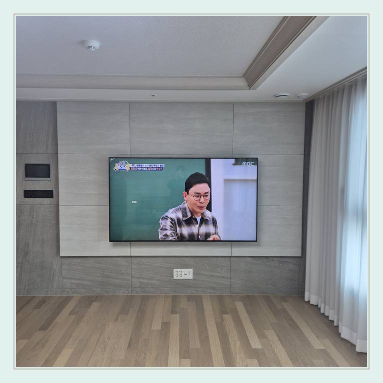 벽면에 걸린 TV와 창가 쪽 간격와 거치대 잠금 나사 확인 안내 사진