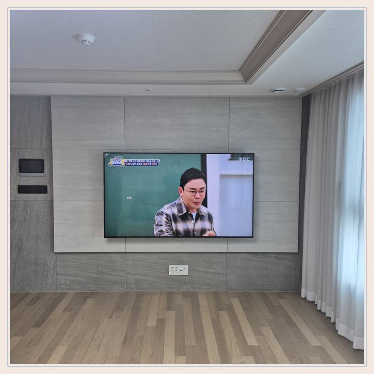 벽면에 걸린 TV와 창가 쪽 간격와 낡은 거치대 부품 교체 안내 사진